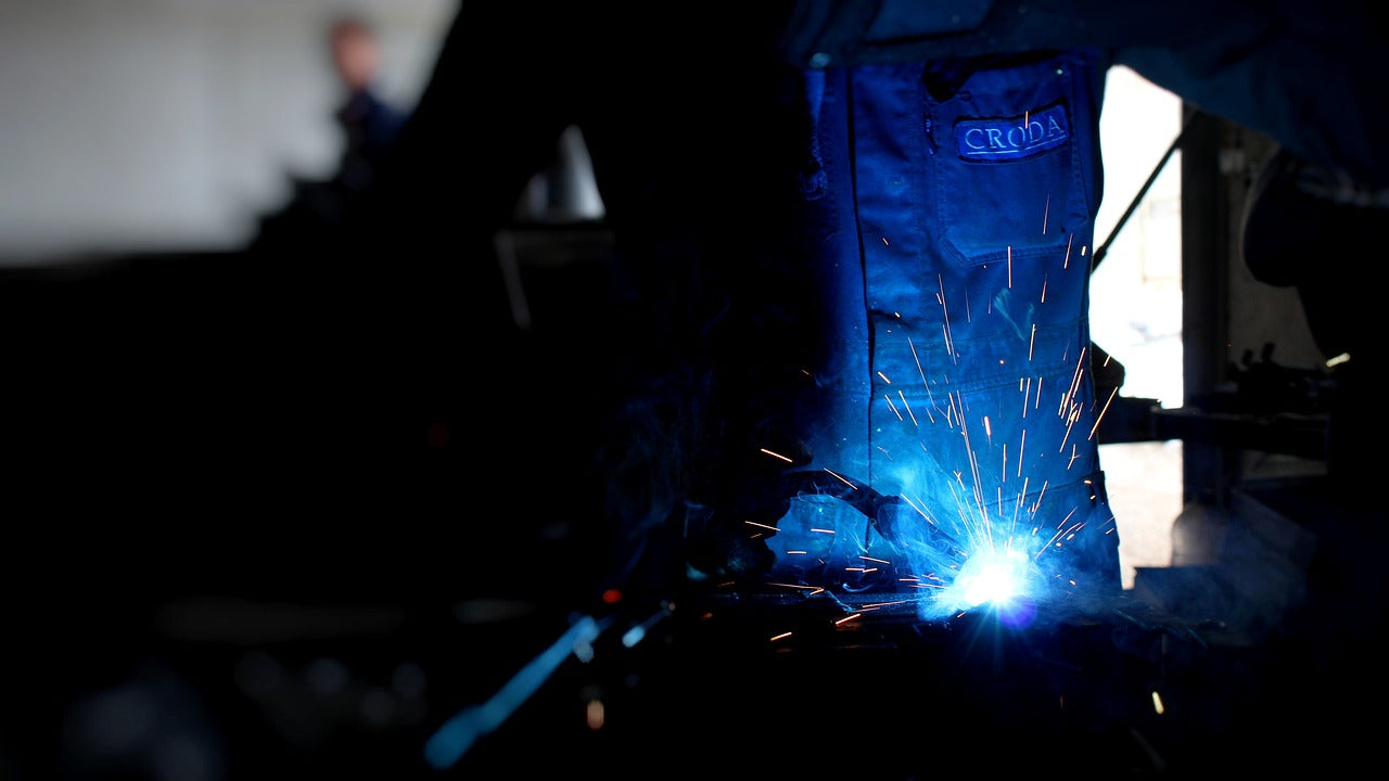 welder welding aluminium plates on a bench