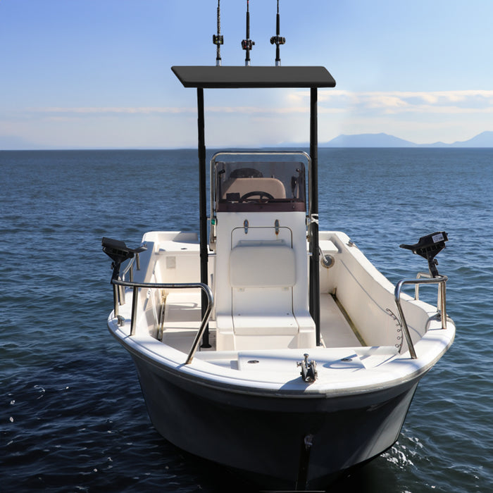 A white center console boat with a black T-top canopy and multiple fishing rods mounted on the top. The boat is anchored in a calm bay with mountains in the background.