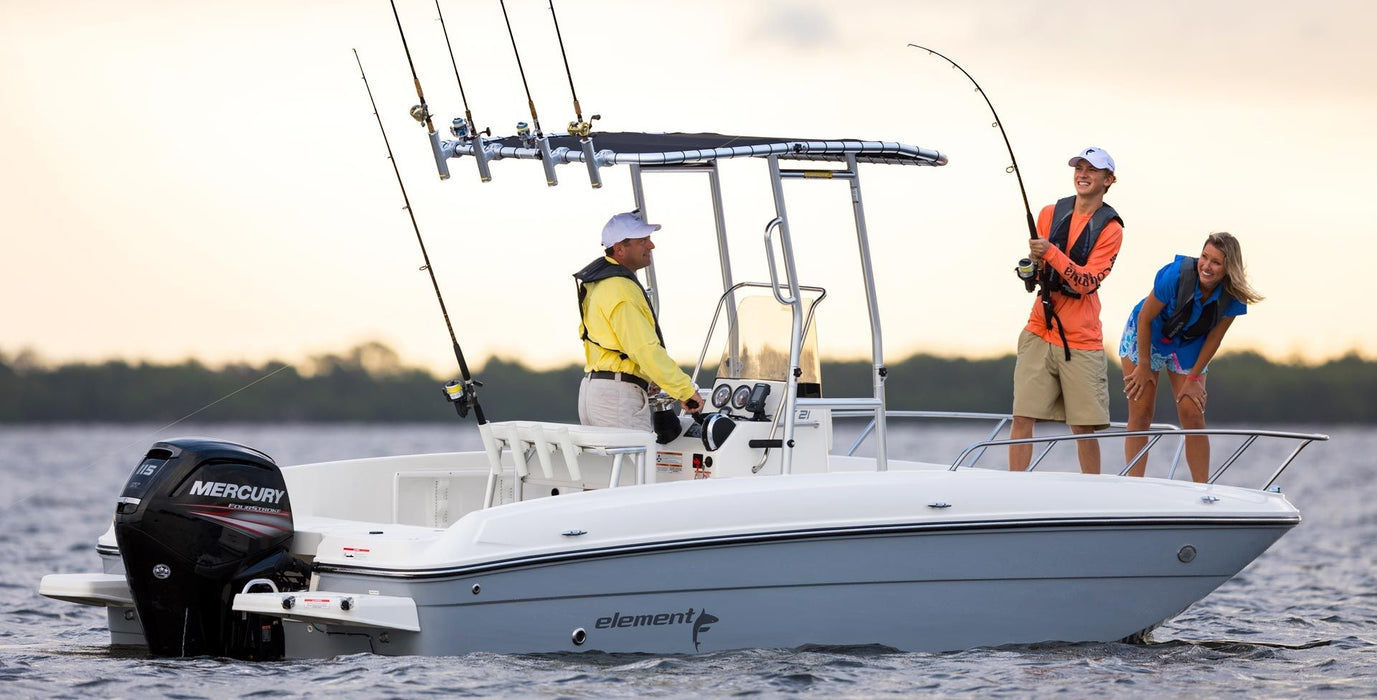 A Bayliner Element F21 boat equipped with a Fishmaster T-top made of marine canvas. Two people are fishing from the boat. The boat is anchored in open water with a scenic background. This boat accessory provides shade and protection for the occupants.