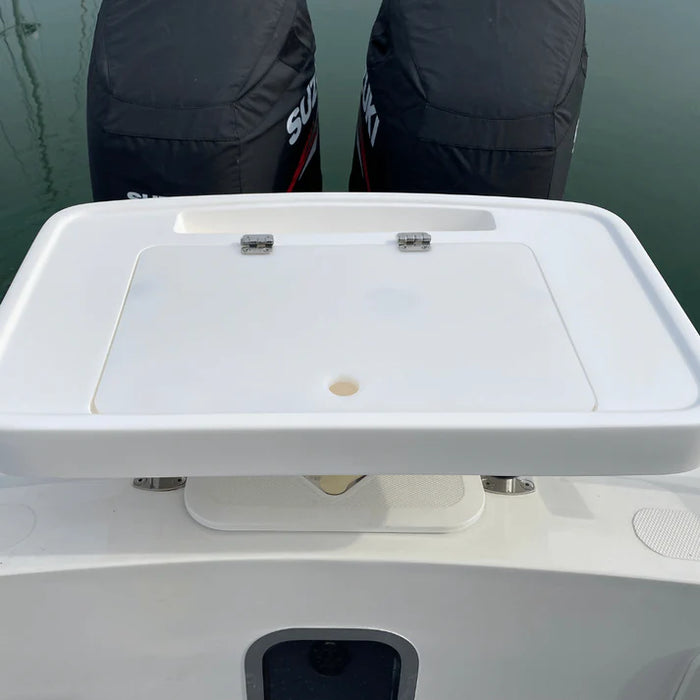 White, rectangular fishing bait station mounted on the back of a boat with two outboard motors covered in black engine covers. The station has a hinged lid and several smaller compartments.