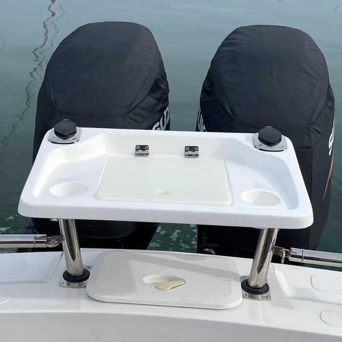  A white, rectangular fishing bait station mounted on the back of a boat with two outboard motors covered in black engine covers. The station has a hinged lid and several smaller compartments. The station is supported by two stainless steel legs. The "SUZUKI" logo is visible on one of the engine covers.