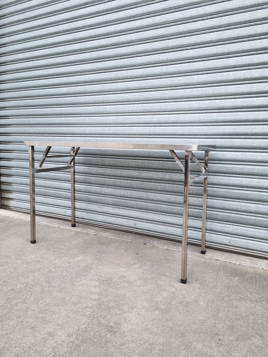 Stainless Steel folding table in front of garage roller door