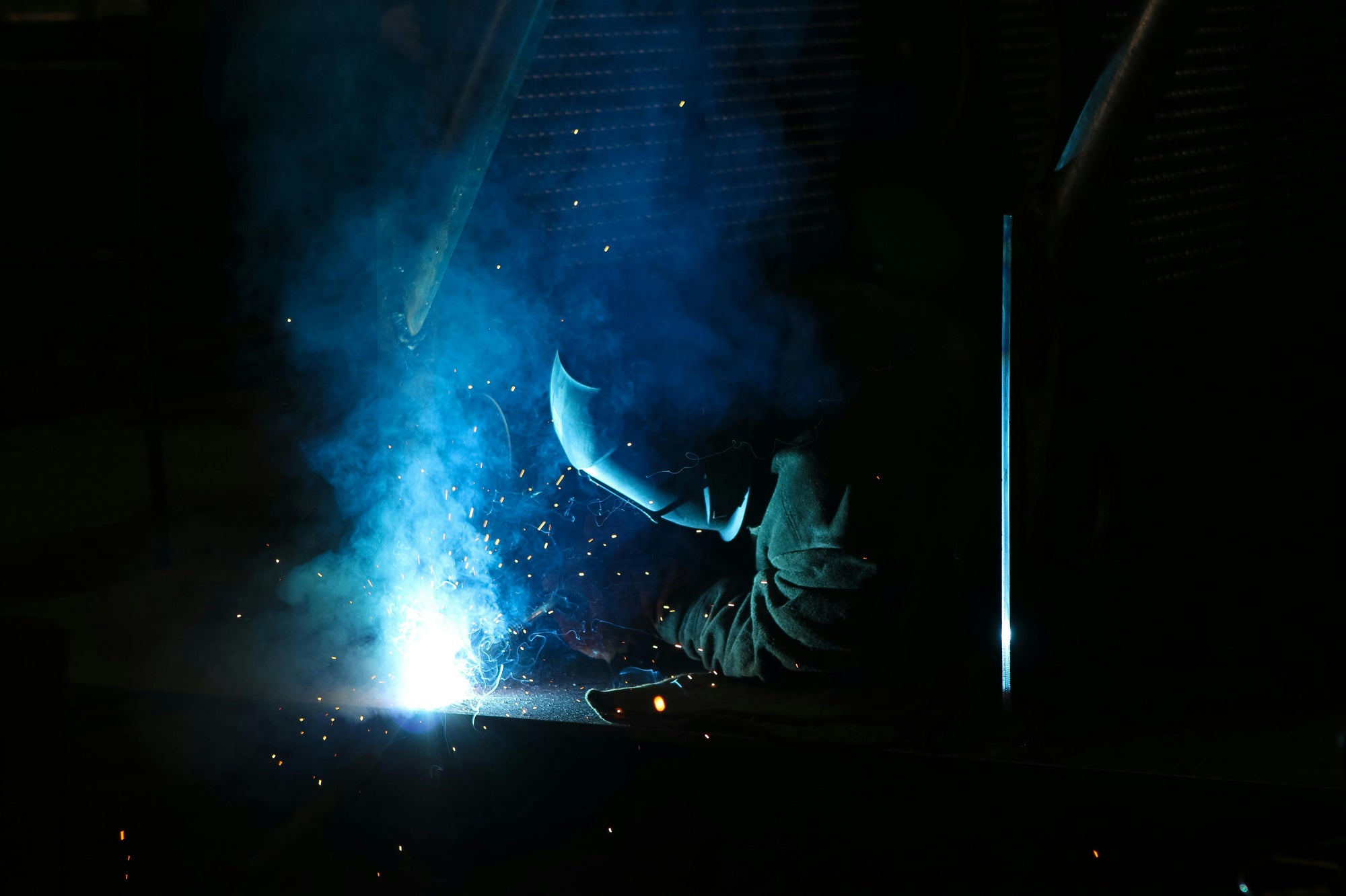 a welder welding stainless steel in the dark on a workbench at mount marine engineering